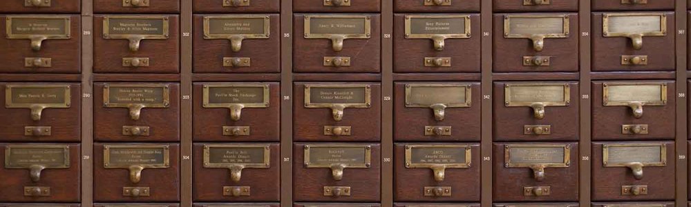 Photo of a stack of card catalog drawers||||