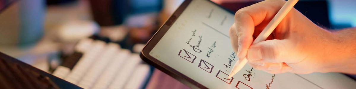 Photo of a person with a tablet checking off a list of things