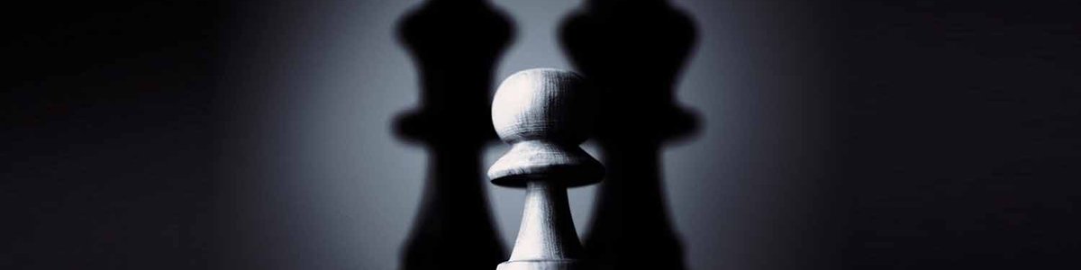 Photo of a pawn in the shadows of the king and queen pieces
