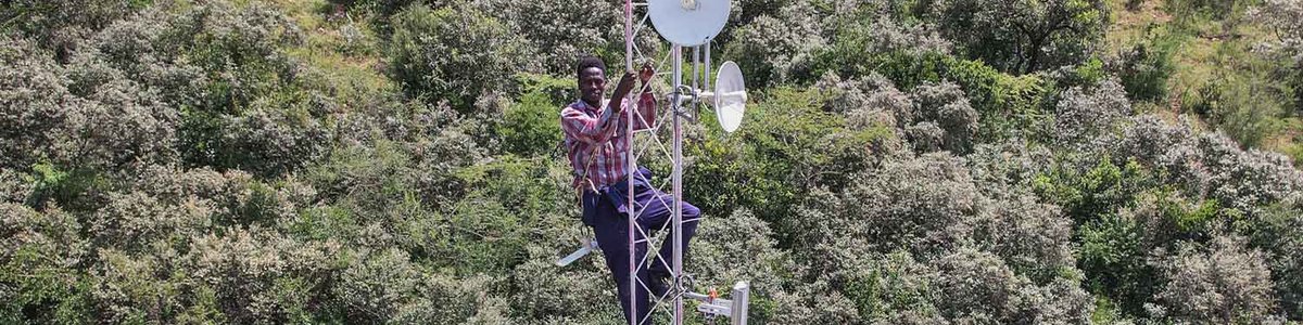 Photo of an engineer standing on a Connectivity Tower at Namelok Community Network, Kajiado West established with the Support of ISOC Kenya Chapter and Help NGO.jpg|||