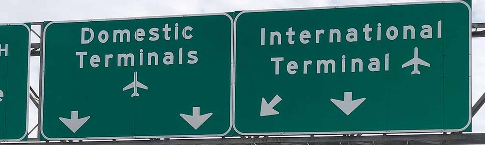 Photo of highway signs pointing to domestic and international terminals|