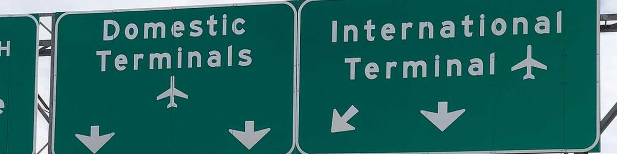 Photo of highway signs pointing to domestic and international terminals|