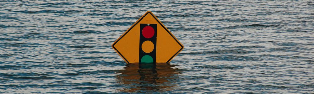 Photo of a road sign almost covered by flood water