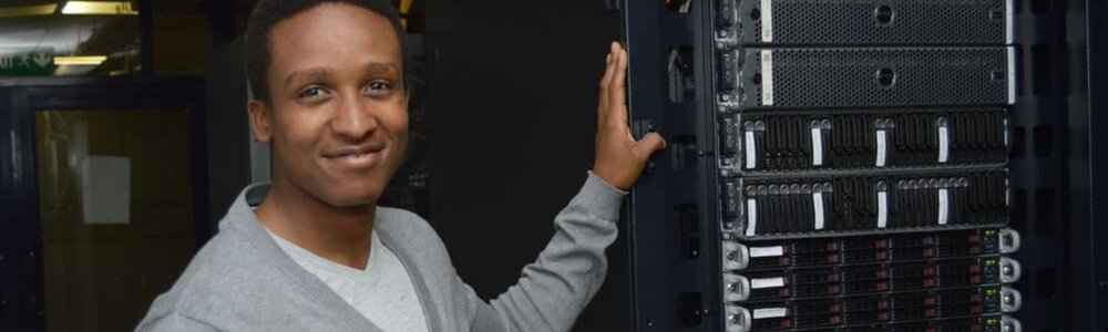 Photo d'une personne debout devant un rack de réseau contenant un commutateur IXP||||||