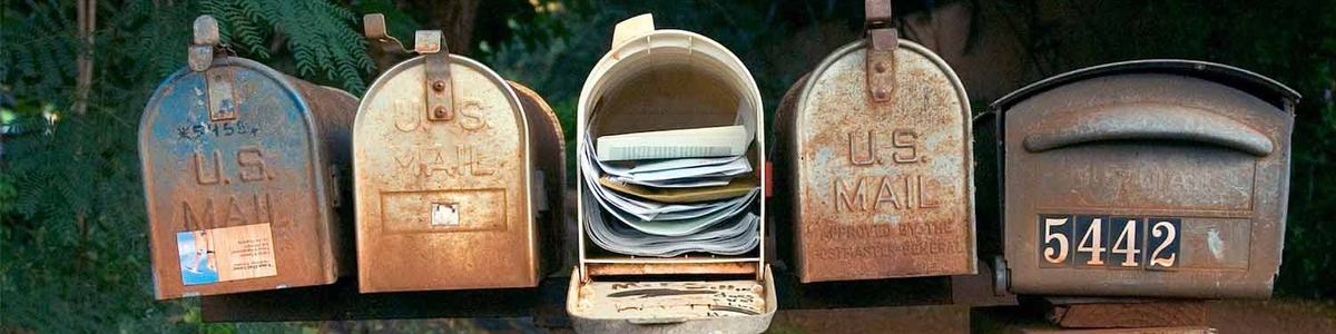 Photo of five mailboxes, one of which is full