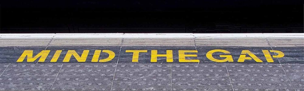 Photo of a station platform showing the words Mind the Gap||