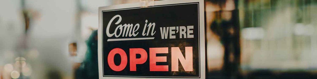 Photo of a sign on front of door saying 'Open'
