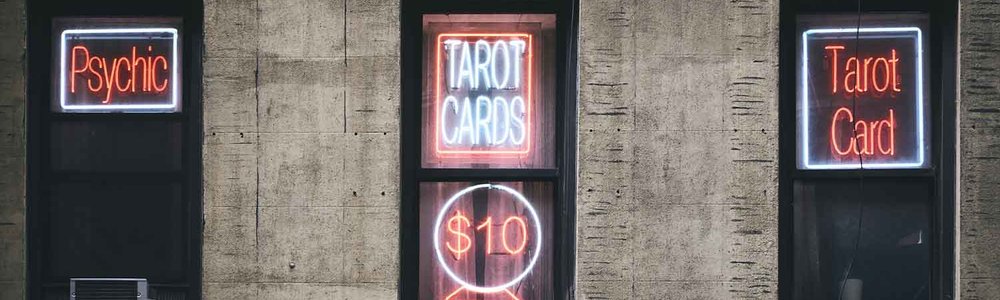 A photo of three doors with signs on them saying "Psychic" "Tarot cards" and "Tarot Card"