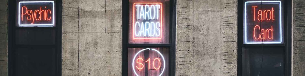 A photo of three doors with signs on them saying "Psychic" "Tarot cards" and "Tarot Card"
