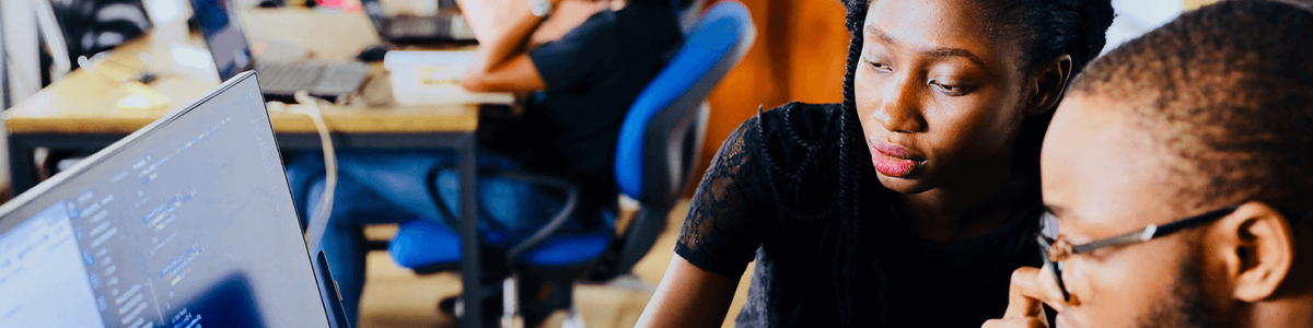 Photo of two people looking at a computer screen