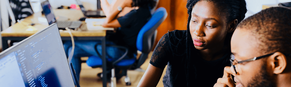 Photo de deux personnes regardant un écran d'ordinateur