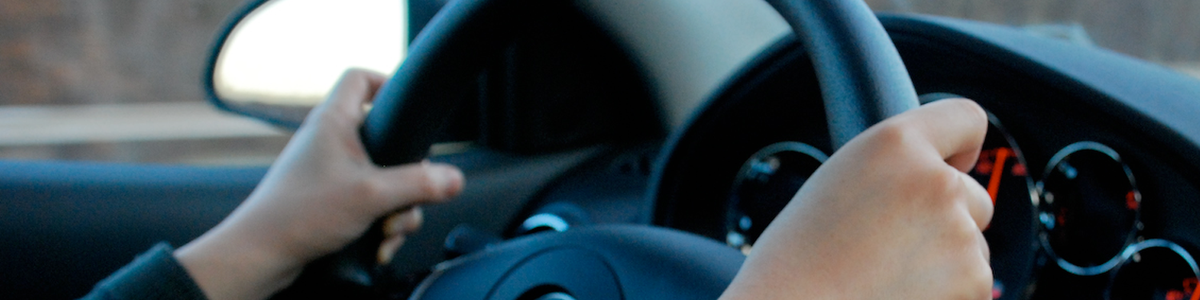 Photo of two hands on a steering wheel