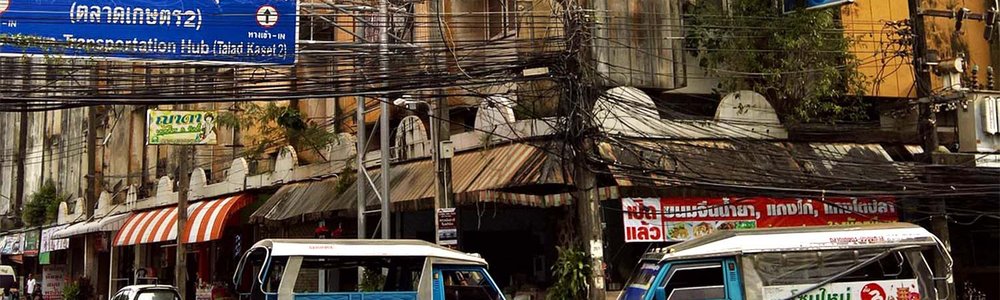 Photo of fiber cables hung up above a street in Thailand.||||||