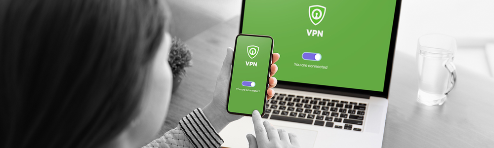 Photo of a lady using a VPN on a mobile and laptop