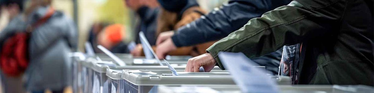 People putting voting slips into ballot boxes