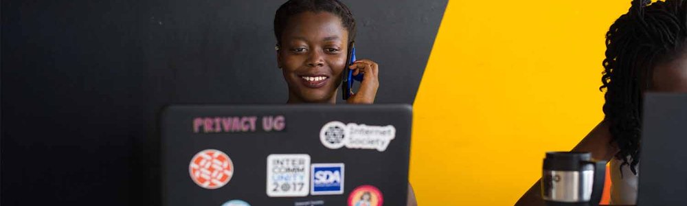 Photo of a woman working at her computer while talking on a phone|