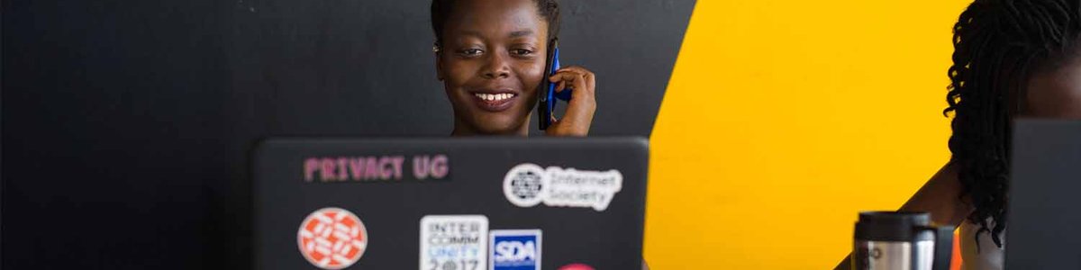 Photo of a woman working at her computer while talking on a phone|