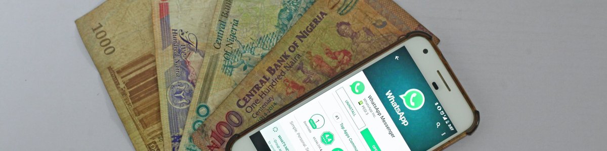A mobile phone showing whatsapp and Nigerian bank notes||