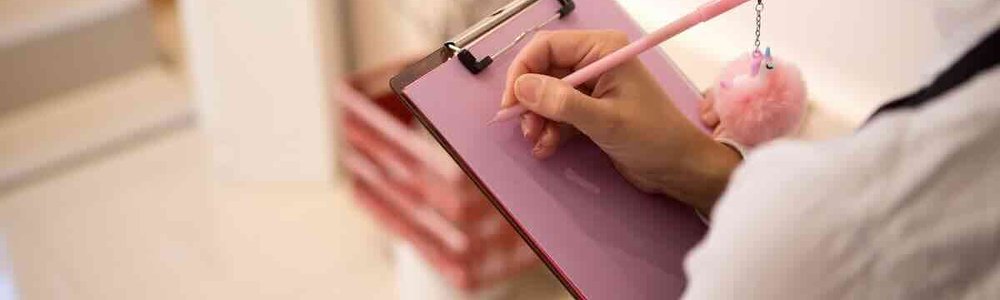 Photo of a lady holding a clipboard and pen
