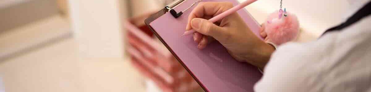 Photo of a lady holding a clipboard and pen