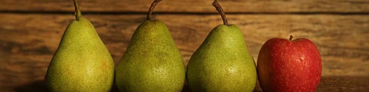 Una foto de tres peras y una manzana