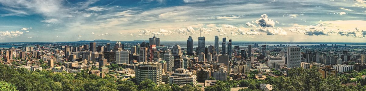 Panoramic view of Montreal, Canada featuring tall buildings and trees.