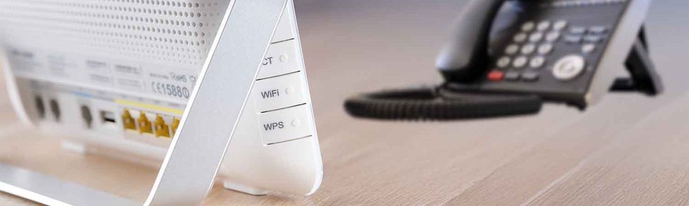 Photo of a modem and a telephone on a desk||