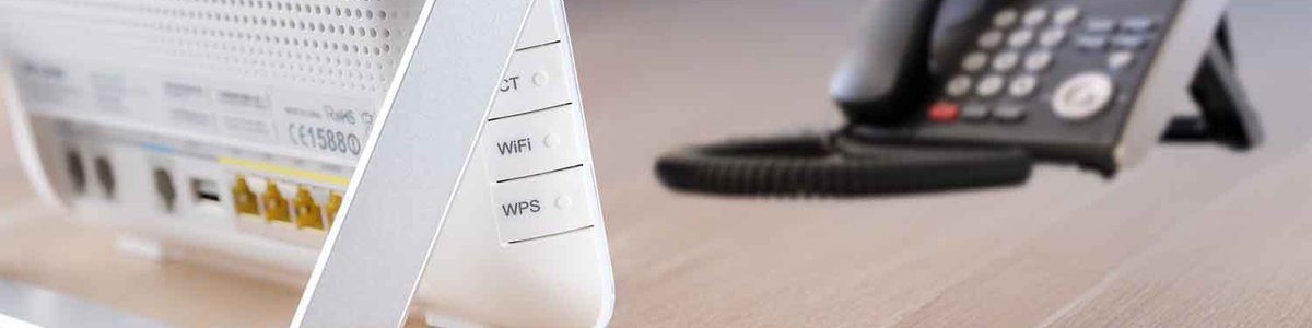 Photo of a modem and a telephone on a desk||