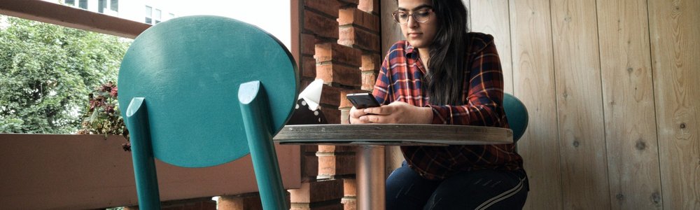 Indian woman in cafe with mobile phone|