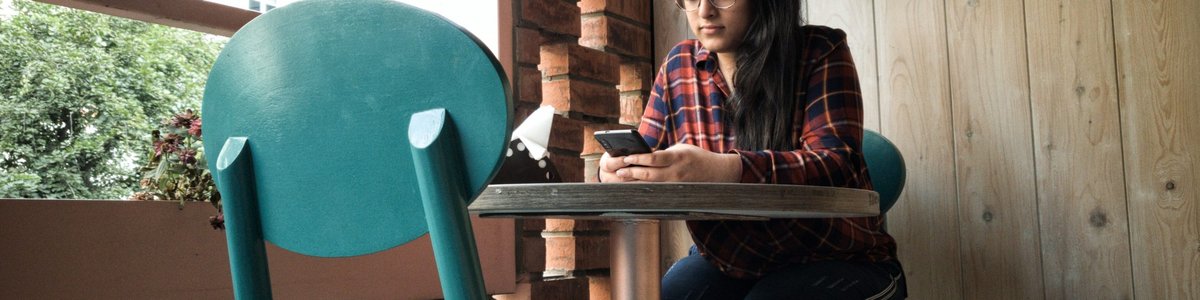 Indian woman in cafe with mobile phone|
