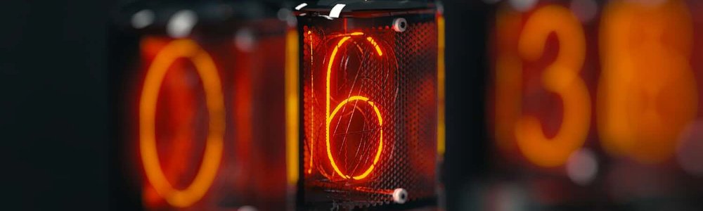 A close up photo of a clock on a table showing six.