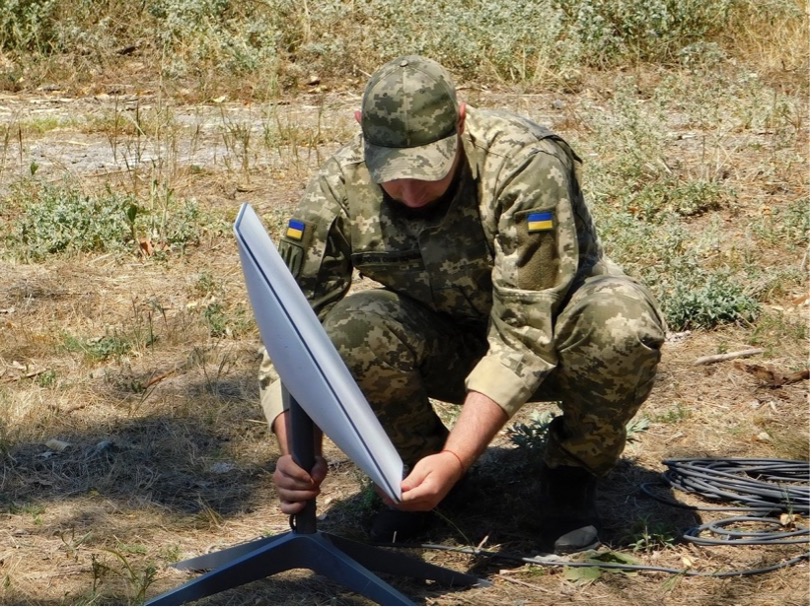 A Ukrainian soldier installs starlink