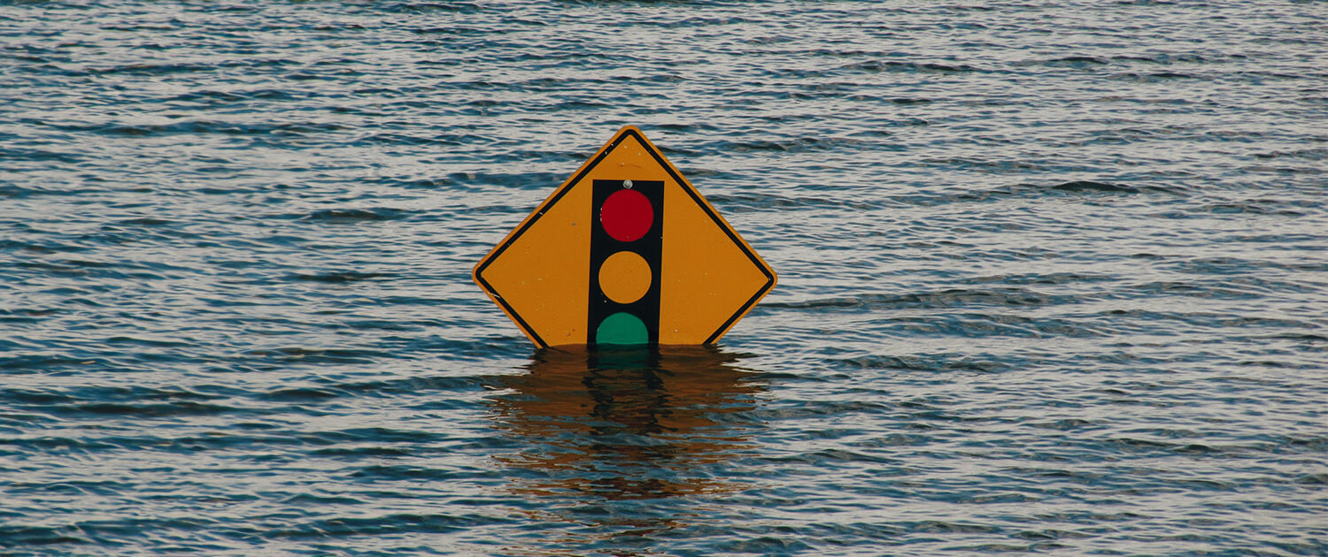 Photo of a road sign almost covered by flood water