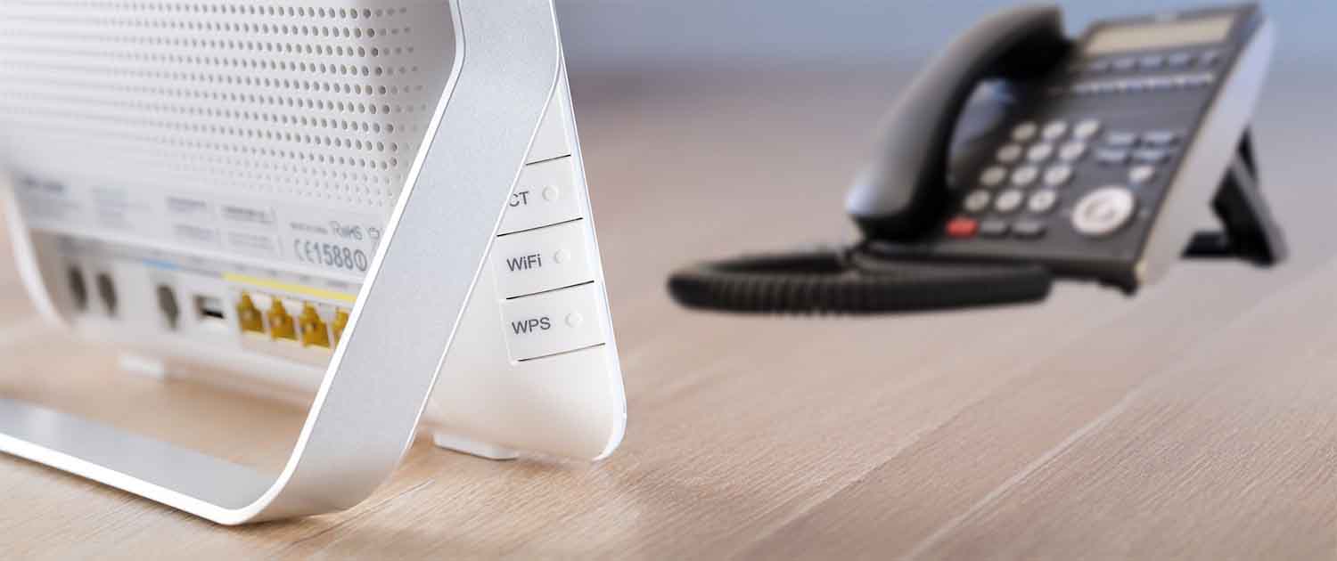 Photo of a modem and a telephone on a desk