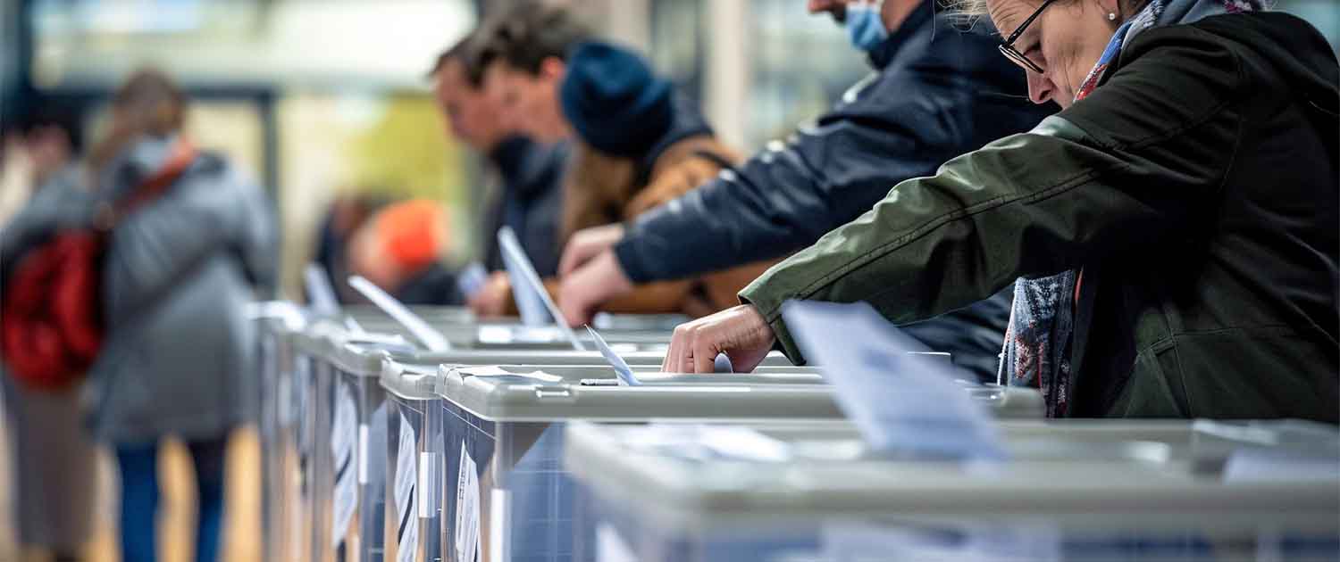 People putting voting slips into ballot boxes