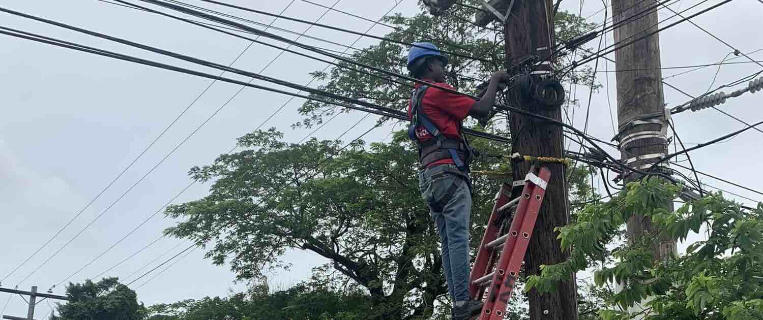 Photo of a worker fixing telephone wires