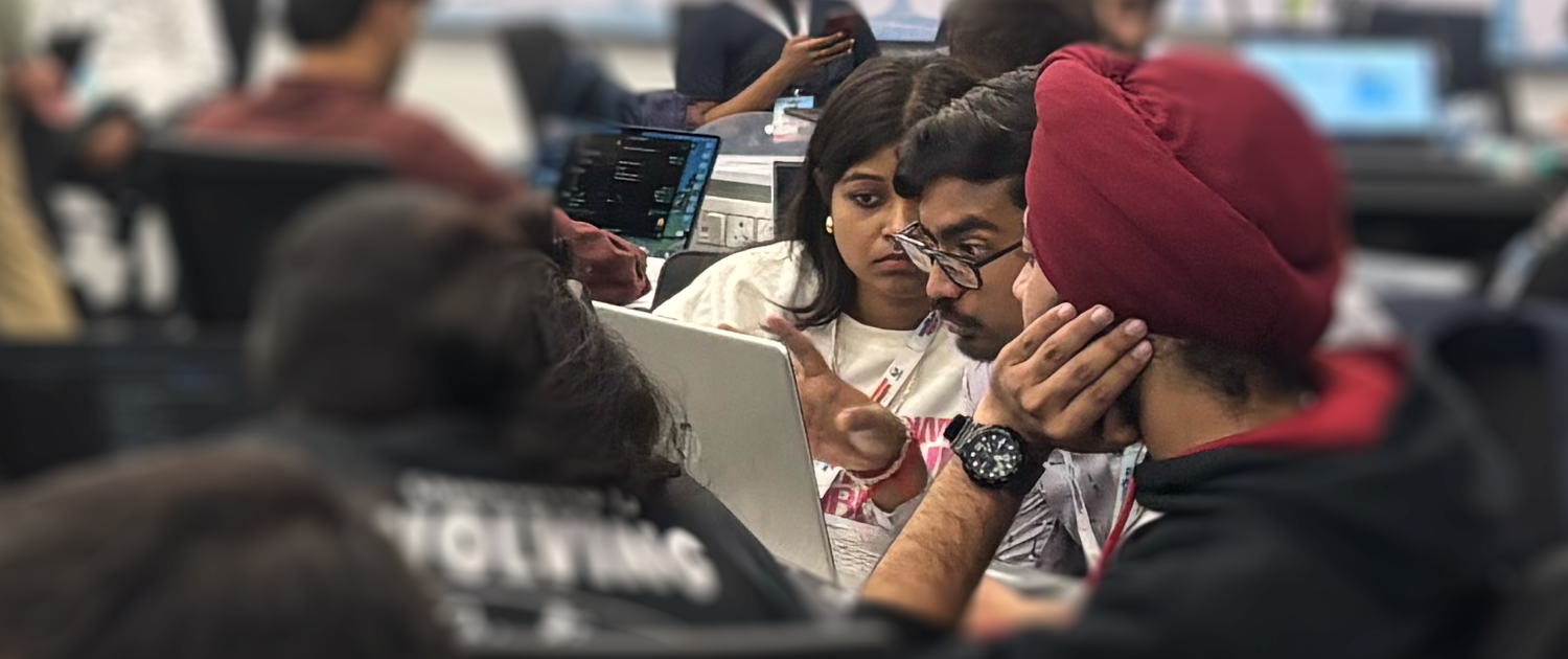 A photo of colleagues conversing about work on a computer